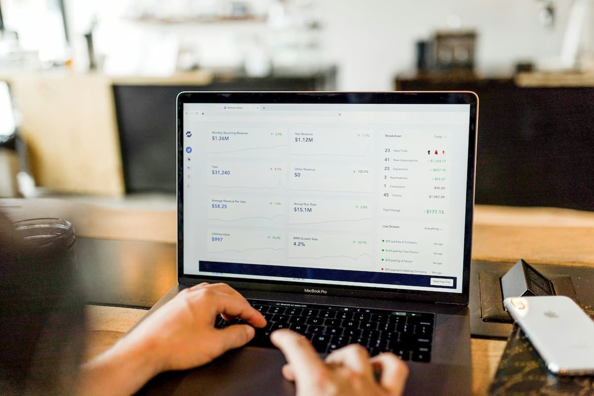 Laptop showing financial charts and revenue data in a café setting