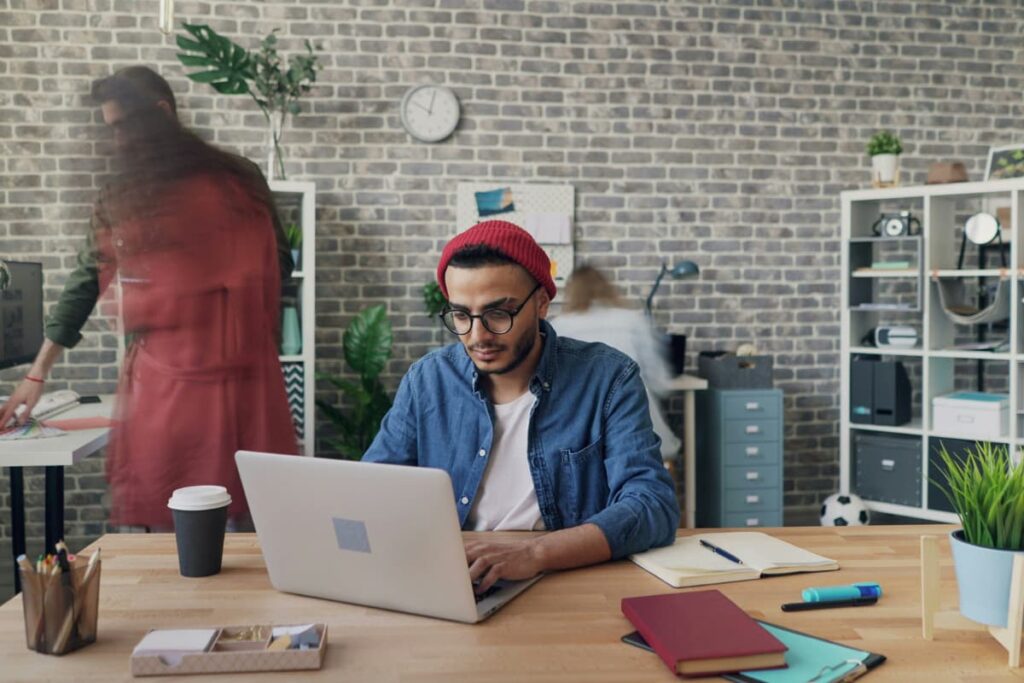 Man working on a laptop in a modern office, representing accounting tasks that can be automated for better efficiency.