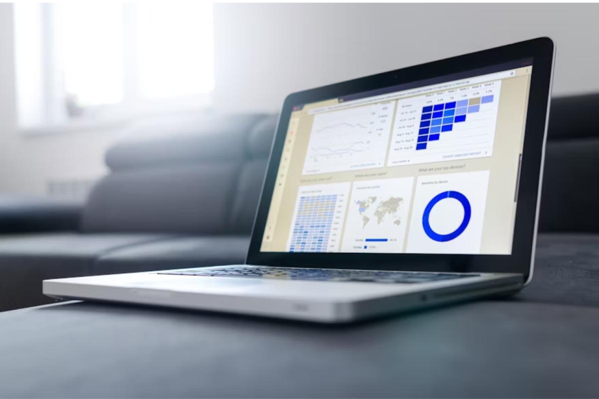 A laptop on a couch displays a graph, illustrating data analysis in a comfortable setting.