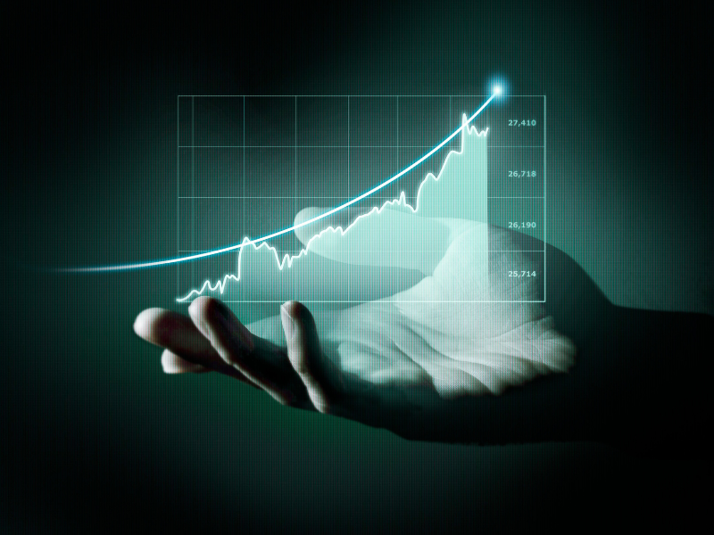 The image shows an open hand, with the palm facing up, as if holding or presenting something. The background is dark with a slight greenish-blue tint.