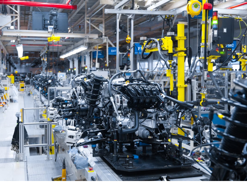 The image shows a modern engine assembly line in a high-tech automotive manufacturing plant. It captures the advanced production environment where vehicle engines are built and assembled.